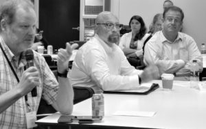 Pierce Crowell asks a question as Alan King and Robert Baker listen